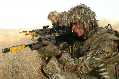 Soldiers in camouflage pointing a gun